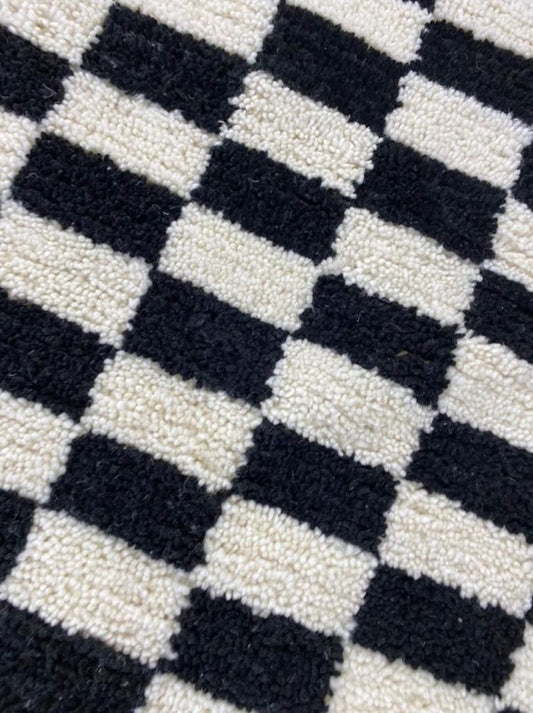 Tapis marocain noir et blanc, motif à carreaux irréguliers fait à la main pour un look chic.